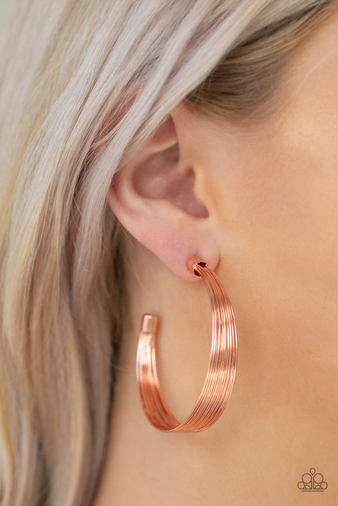 Attached to two shiny copper fittings, wire after wire stacks into an edgy hoop. Earring attaches to a standard post fitting. Hoop measures 2" in diameter.  Sold as one pair of hoop earrings.