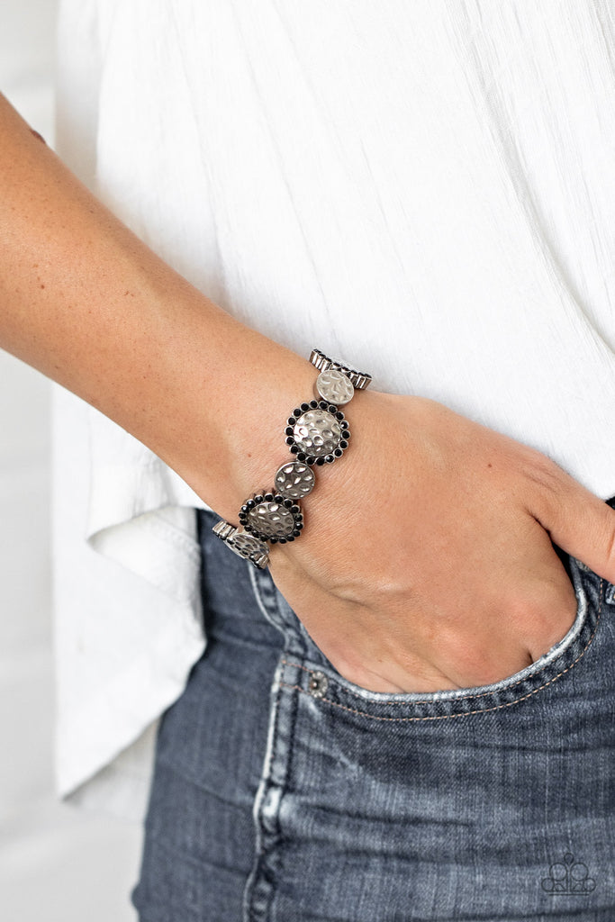 Ringed in glittery black rhinestones, hammered silver frames alternate with dainty hammered discs along stretchy bands around the wrist for a refined flair.  Sold as one individual bracelet.