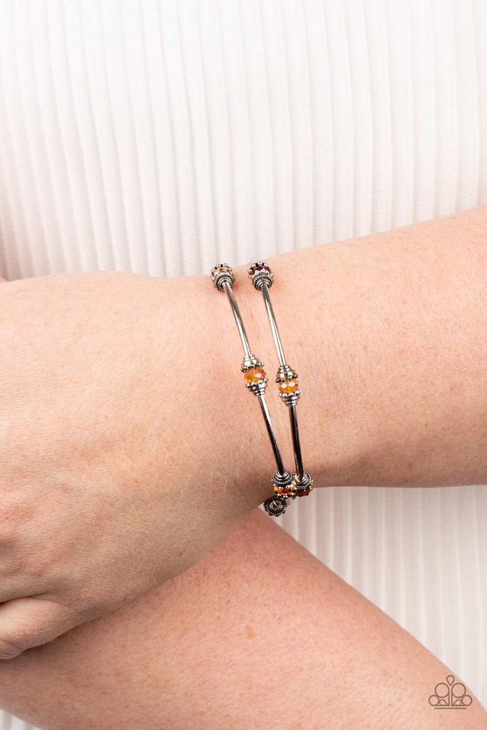 Dainty orange crystal-like beads and shimmery silver accents alternate along a coiled wire to create a refined infinity wrap style bracelet.  Sold as one individual bracelet.