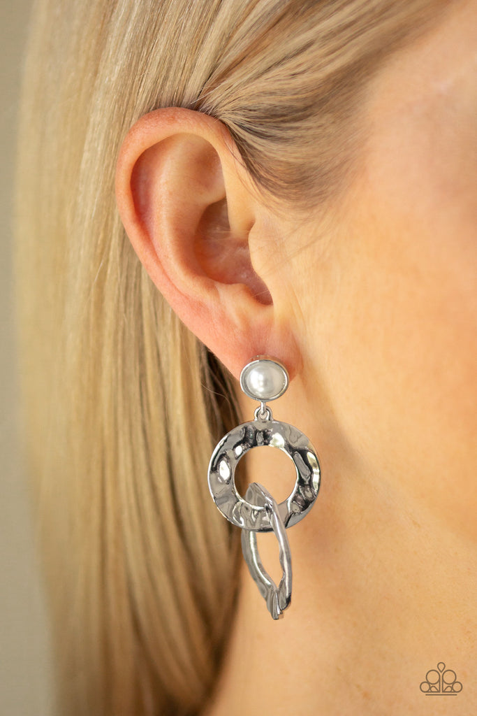 Hammered silver rings link at the bottom of a solitaire white pearl dotted frame for a refined edge. Earring attaches to a standard post fitting.  Sold as one pair of post earrings.