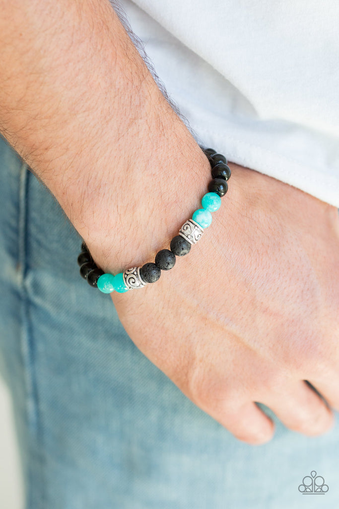 Infused with ornate silver accents, an earthy collection of glassy black beads, blue stone beads, and black lava rock beads are threaded along a stretchy band around the wrist for a seasonal look.  Sold as one individual bracelet.