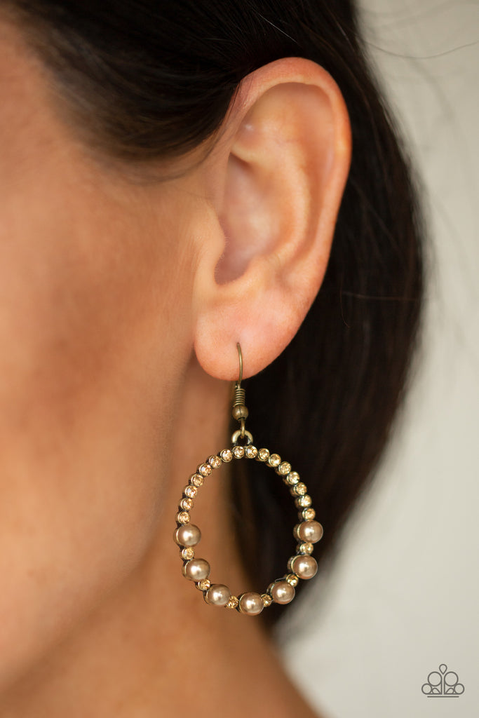 Encrusted in glassy topaz rhinestones, the bottom of a glistening brass hoop is dotted in bubbly brass pearls for a refined fashion. Earring attaches to a standard fishhook fitting.  Sold as one pair of earrings.