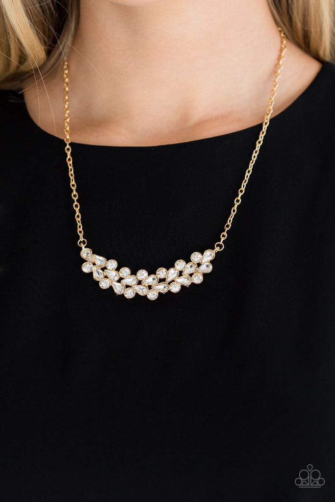 A collection of round and teardrop white rhinestones coalesce into a bowing gold pendant below the collar for a refined look. Features an adjustable clasp closure.  Sold as one individual necklace. Includes one pair of matching earrings.