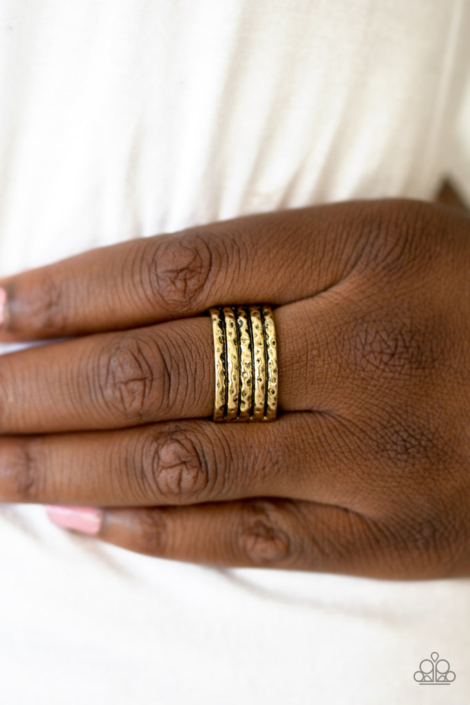 Delicately hammered in shimmery textures, glistening brass bars layer across the finger, coalescing into an edgy band. Features a stretchy band for a flexible fit.  Sold as one individual ring.
