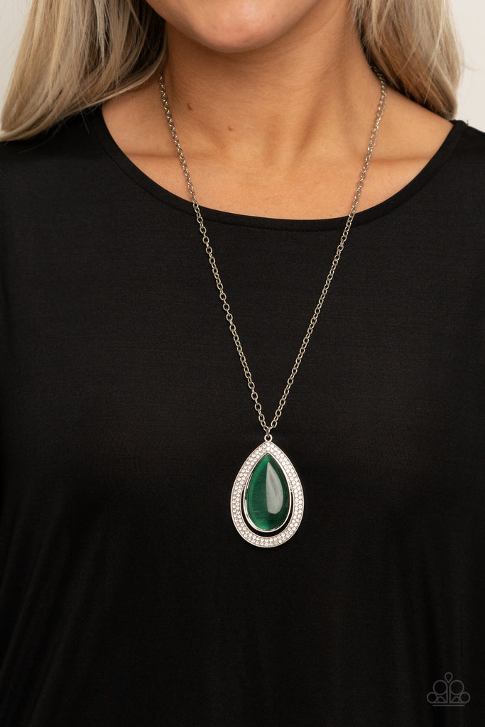 An oversized green cat's eye teardrop attaches to the top of a silver teardrop frame encrusted in glassy white rhinestones at the bottom of a lengthened silver chain, creating a glamorous pendant. Features an adjustable clasp closure.  Sold as one individual necklace. Includes one pair of matching earrings.   