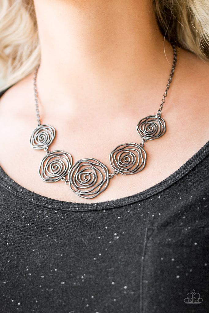 Gradually increasing in size near the center, radiant gunmetal bars spin into charming rosebud frames below the collar for a whimsical look. Features an adjustable clasp closure.  Sold as one individual necklace. Includes one pair of matching earrings.