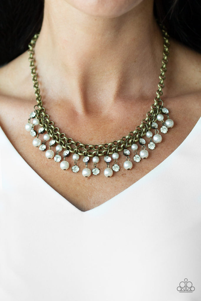 Glittery white rhinestones and classic white pearls swing from the bottom of interlocking brass chains, creating a bubbly fringe below the collar. Features an adjustable clasp closure.  Sold as one individual necklace. Includes one pair of matching earrings.