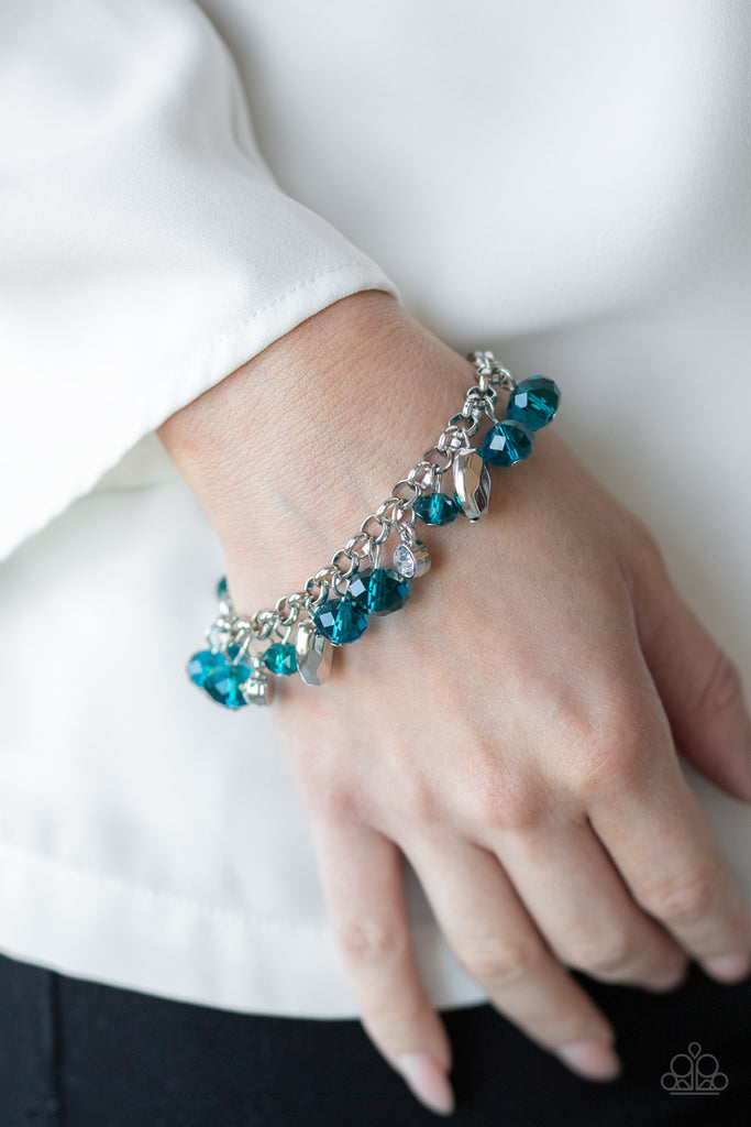 A glittery collection of sparkling white rhinestones, faceted silver beads, and blue crystal-like beads dangle from the wrist, creating a refined fringe. Features an adjustable clasp closure.  Sold as one individual bracelet.