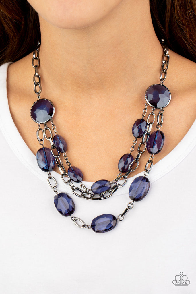 Strung between two matching Blue Depths gem-like fittings, two glittery rows of Blue Depths oval gems flank a strand of bold gunmetal chain below the collar for a flawlessly layered look. Features an adjustable clasp closure.  Sold as one individual necklace. Includes one pair of matching earrings