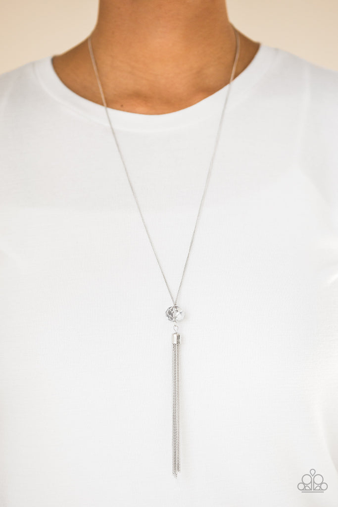 Splashed in metallic shimmer, a smoky crystal-like bead swings from the bottom of a lengthened silver chain, giving way to a shimmering silver tassel for a glamorous finish. Features an adjustable clasp closure.  Sold as one individual necklace. Includes one pair of matching earrings.
