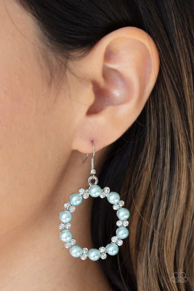 Pairs of dainty white rhinestones and solitaire blue pearls are encrusted along the front of a shimmery silver hoop for a refined look. Earring attaches to a standard fishhook fitting.  Sold as one pair of earrings.
