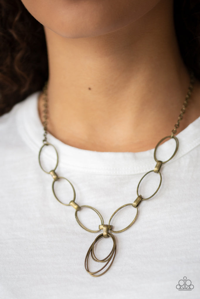 Varying in size, a collection of oval frames swing from the bottom of a strand of double-linked oval frames, creating a casual pendant below the collar. Features an adjustable clasp closure.  Sold as one individual necklace. Includes one pair of matching earrings.