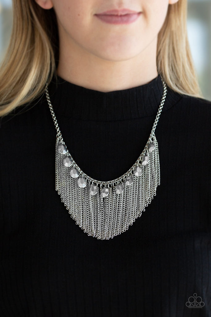 A row of faceted silver teardrops and free-falling silver chains drape below the collar, creating a dramatic fringe for a show-stopping style. Features an adjustable clasp closure.  Sold as one individual necklace. Includes one pair of matching earrings.