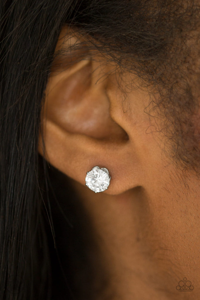 A sparkling white rhinestone is nestled inside a classic silver frame for a timeless look. Earring attaches to a standard post fitting.  Sold as one pair of post earrings.