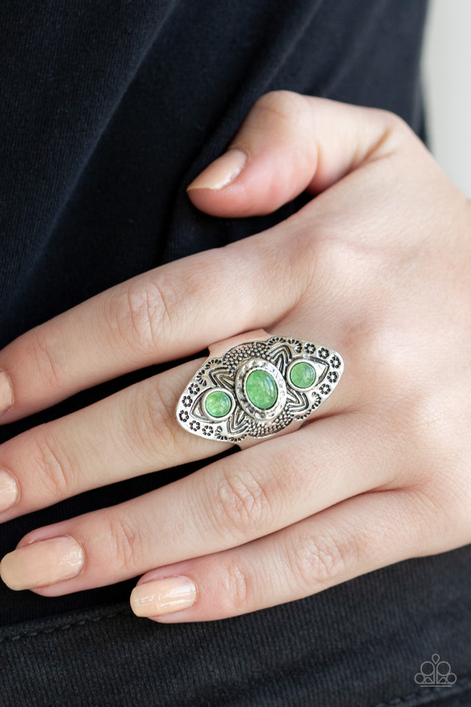 Stamped and studded in tribal inspired patterns, a thick silver frame folds around the finger. Glassy green stones are pressed down the ornate frame for a colorful finish. Features a stretchy band for a flexible fit.  Sold as one individual ring