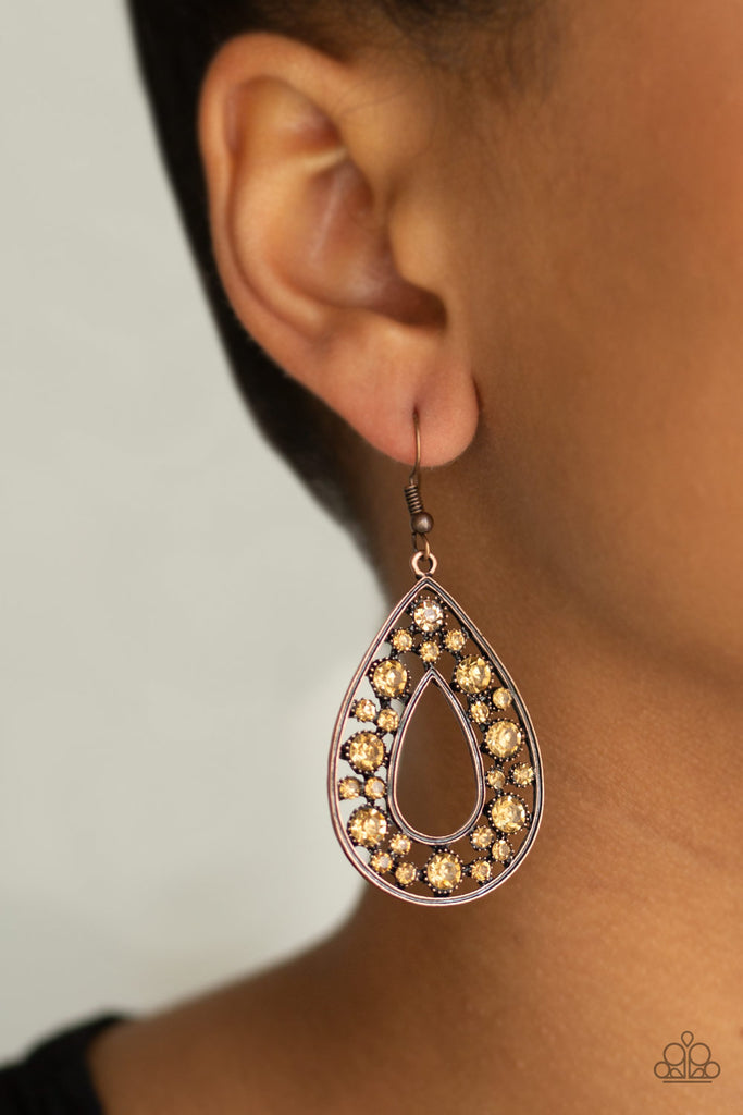 Pressed into studded copper fittings, a collection of golden topaz rhinestones collect inside of a brass teardrop, creating a sparkling frame. Earring attaches to a standard fishhook fitting.  Sold as one pair of earrings.