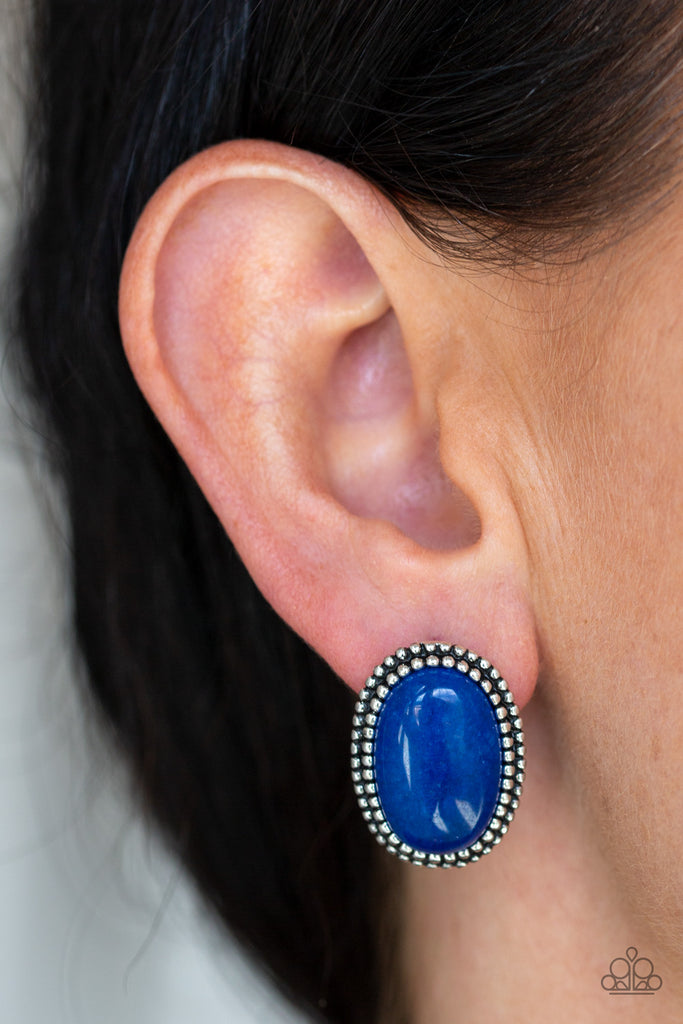 A studded silver frame spins around a glassy blue stone, creating a whimsical frame. Earring attaches to a standard post fitting.  Sold as one pair of post earrings.