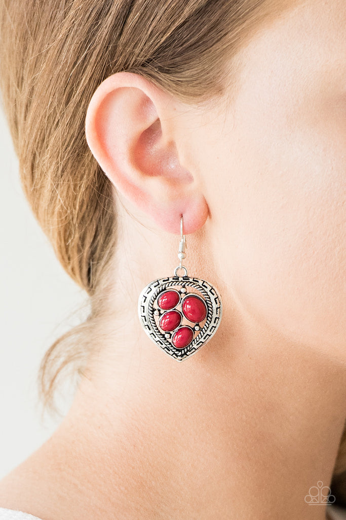 Varying in size, polished red beads are sprinkled across the center of an asymmetrical heart-shaped frame for a whimsical look. Earring attaches to a standard fishhook fitting.  Sold as one pair of earrings.