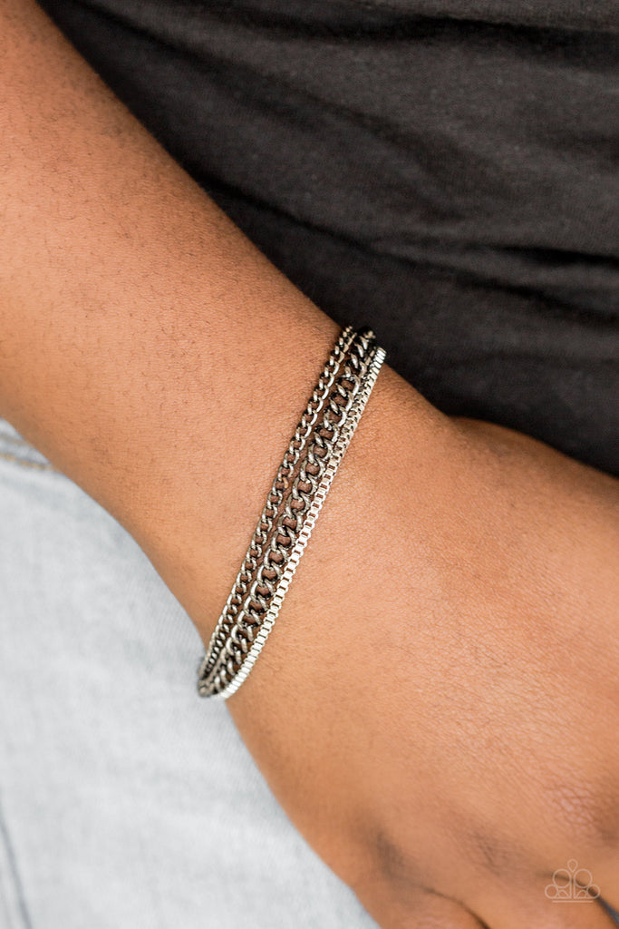 Dainty silver box chain and mismatched gunmetal chains layer across the wrist, creating a collision of industrial textures. Features an adjustable clasp closure.  Sold as one individual bracelet.