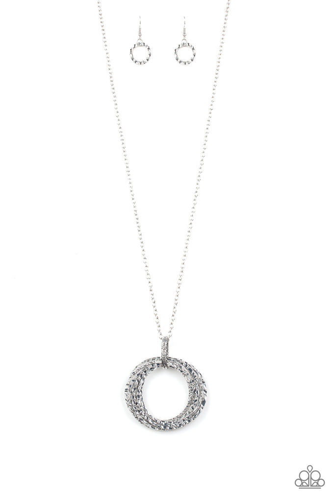 Featuring a hammered finish, a collection of interlocking silver hoops are threaded through the center of textured silver fittings. The dizzying pendant swings from the bottom of a lengthened silver chain for a dramatic industrial look. Features an adjustable clasp closure.  Sold as one individual necklace. Includes one pair of matching earring