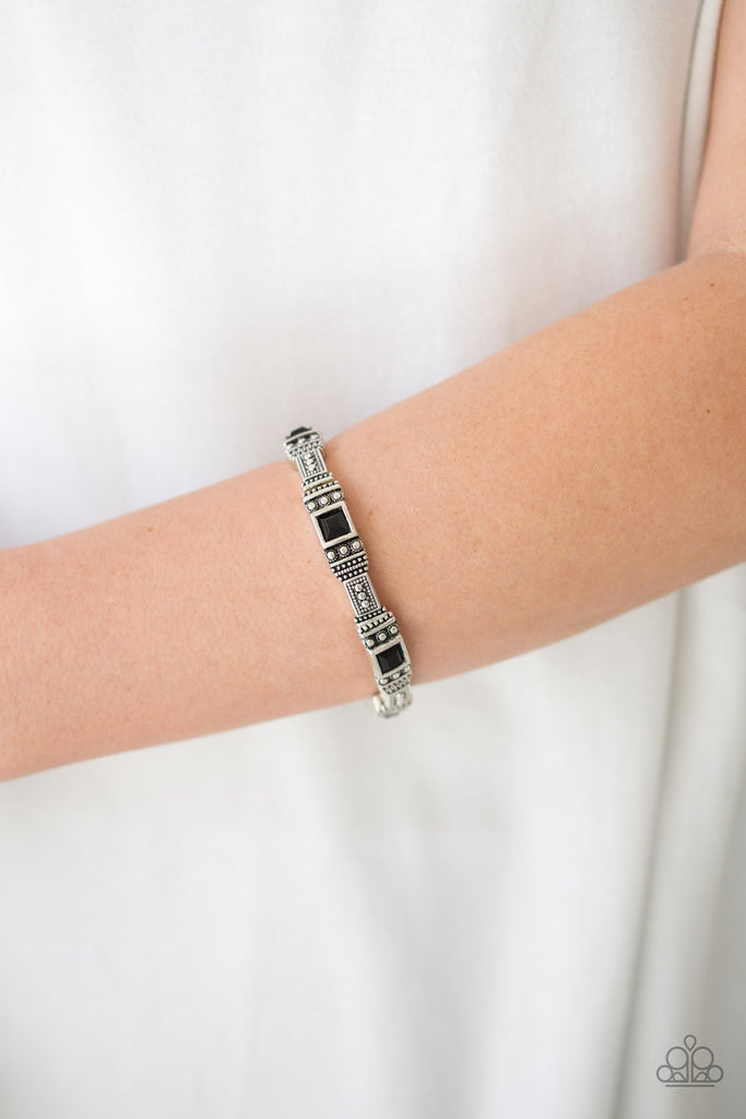 Featuring square black beads, studded silver frames are threaded along a stretchy band around the wrist for a seasonal look.  Sold as one individual bracelet.
