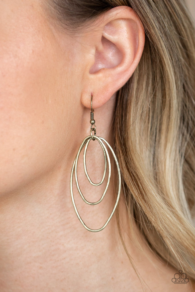 Gradually increasing in size, a trio of brass oval frames trickle from the ear, coalescing into an airy lure. Earring attaches to a standard fishhook fitting.  Sold as one pair of earrings.