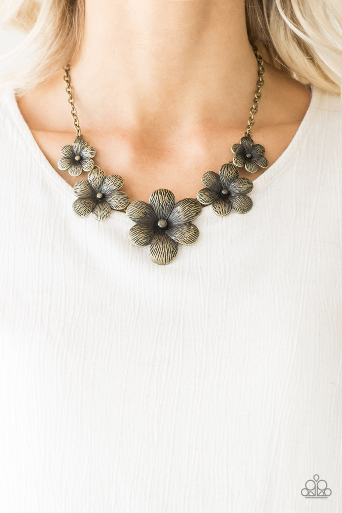 Brushed in an antiqued shimmer, lifelike brass flowers gradually increase in size as they link below the collar in a seasonal fashion. Features an adjustable clasp closure.  Sold as one individual necklace. Includes one pair of matching earrings.