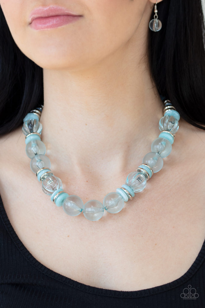 Featuring dainty silver and blue acrylic discs, a collection of oversized glassy blue beads are threaded along an invisible wire below the collar for a colorfully bubbly look. Features an adjustable clasp closure.  Sold as one individual necklace. Includes one pair of matching earrings.