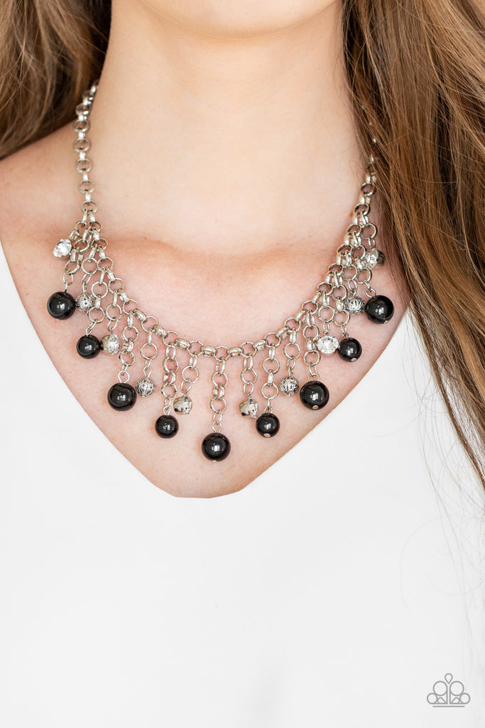 A collection of bubbly black beads, glittery white rhinestones, and ornate silver beads swing from the bottom of a shimmery silver chain, creating a refined fringe below the collar. Features an adjustable clasp closure.  Sold as one individual necklace. Includes one pair of matching earrings.
