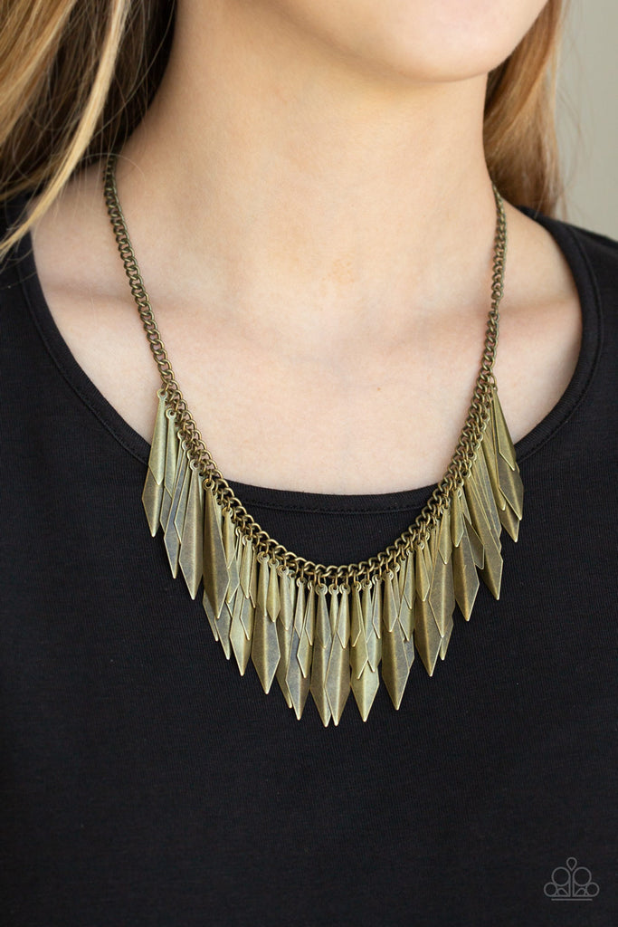 A collection of flared brass daggers swing from the bottom of a glistening brass chain, creating an edgy fringe below the collar. Featuring a subtle crease down the center, the shimmery discs gradually increase in size as they drip from the chain, adding an irresistible industrial flair to the look. Features an adjustable clasp closure.  Sold as one individual necklace. Includes one pair of matching earrings.
