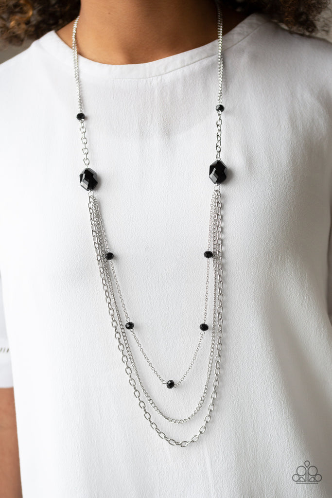 Infused with glassy black beads, a pair of glittery black gems gives way to layers of mismatched silver chains for a dazzling look. Features an adjustable clasp closure.  Sold as one individual necklace. Includes one pair of matching earrings.