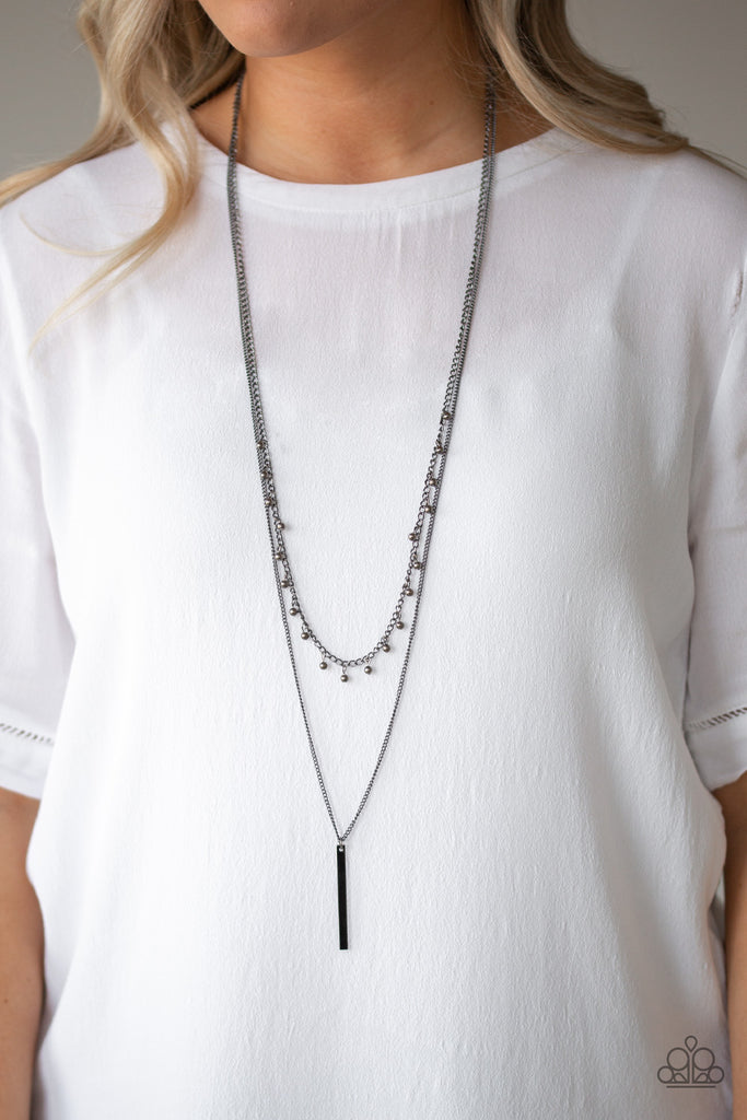Two mismatched gunmetal chains layer down the chest. Dainty gunmetal beads dangle from the bottom of the uppermost chain, while a rectangular pendulum-like pendant swings from the lowermost chain for a casual finish. Features an adjustable clasp closure.  Sold as one individual necklace. Includes one pair of matching earrings.