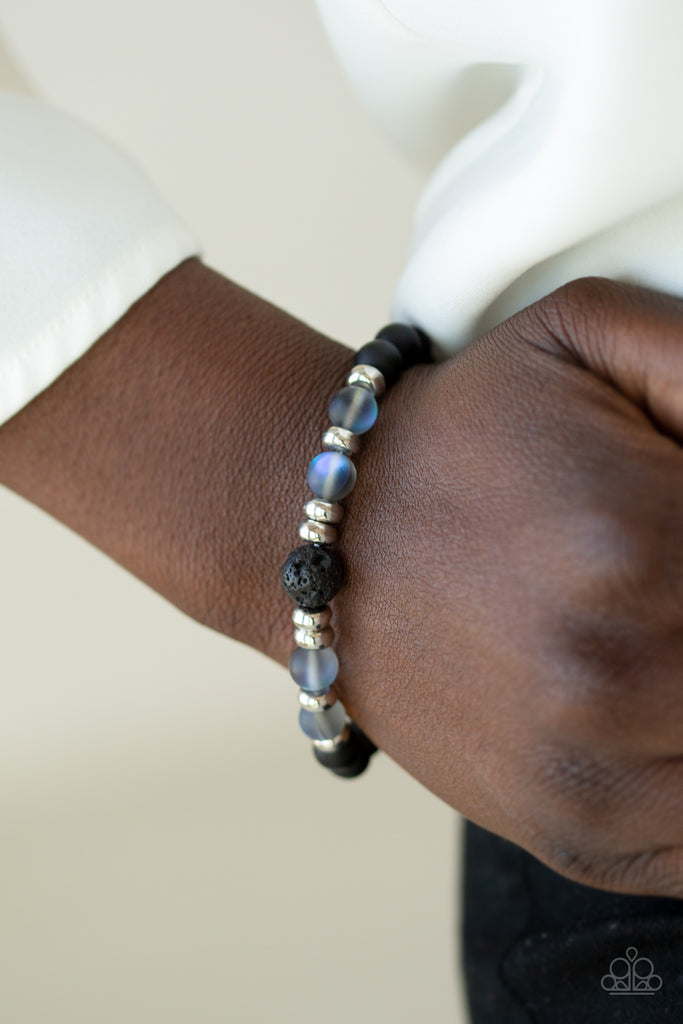 Infused with dainty silver beads, a collection of black stone beads, black lava rock beads, and glassy iridescent beads are threaded along a stretchy band around the wrist for a seasonal flair.  Sold as one individual bracelet.
