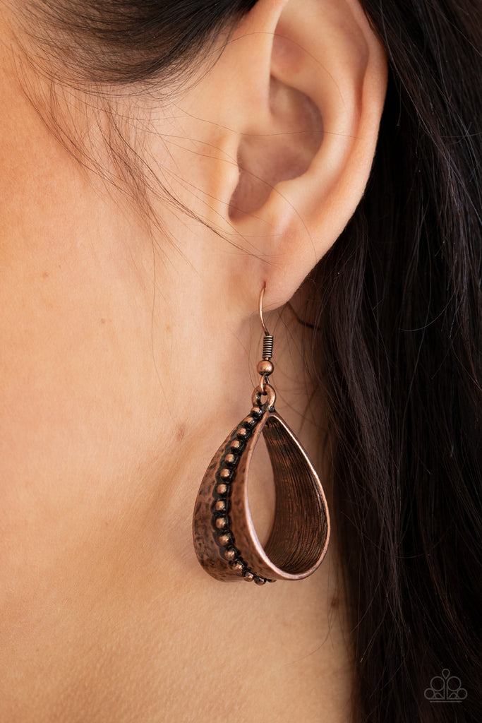 A row of antiqued studs dots the center of a hammered copper frame that curls into a rustic teardrop for a seasonal flair. Earring attaches to a standard fishhook fitting.  Sold as one pair of earrings.