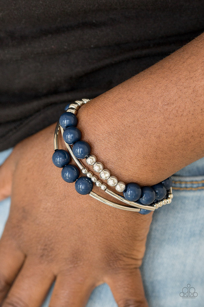 Polished blue beads and mismatched silver beads are threaded along stretchy bands, creating colorful layers across the wrist.  Sold as one set of three bracelets.