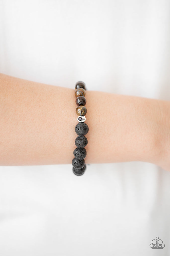 A collection of black lava rock, tiger's eye stones, and ornate silver beads are threaded around the wrist for a seasonal look. Features an adjustable sliding knot closure.  Sold as one bracelet.