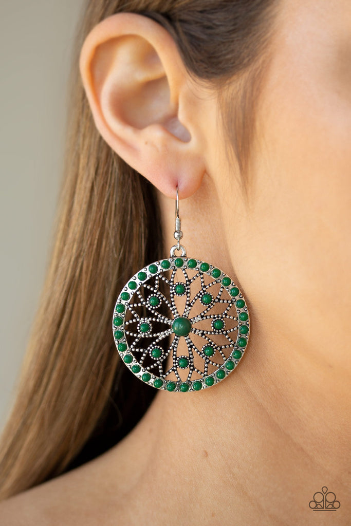 Dainty green beads are sprinkled along a shimmery silver frame swirling with floral filled filigree, creating a whimsical mandala-like frame. Earring attaches to a standard fishhook fitting.  Sold as one pair of earrings.
