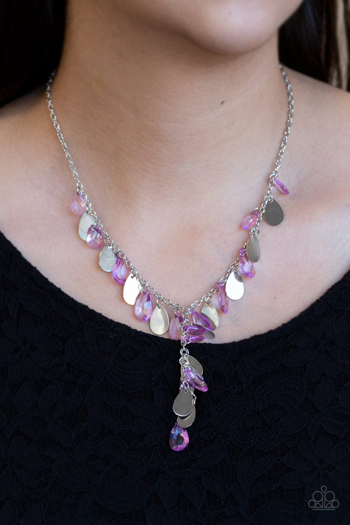 Flat silver teardrops and purple crystal-like teardrops swing from the bottom of a shimmery silver chain below the collar. A matching tassel swings from the center, creating a whimsical extended pendant. Features an adjustable clasp closure.  Sold as one individual necklace. Includes one pair of matching earrings.