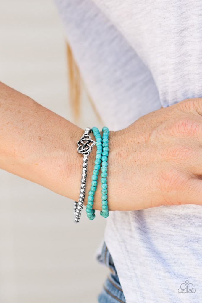 Refreshing turquoise beads and classic silver beads are threaded along elastic stretchy bands, creating colorful layers across the wrist. Brushed in an antiqued shimmer, an airy heart charm adorns the center of the silver beaded strand for a whimsical finish.  Sold as one set of three bracelets.