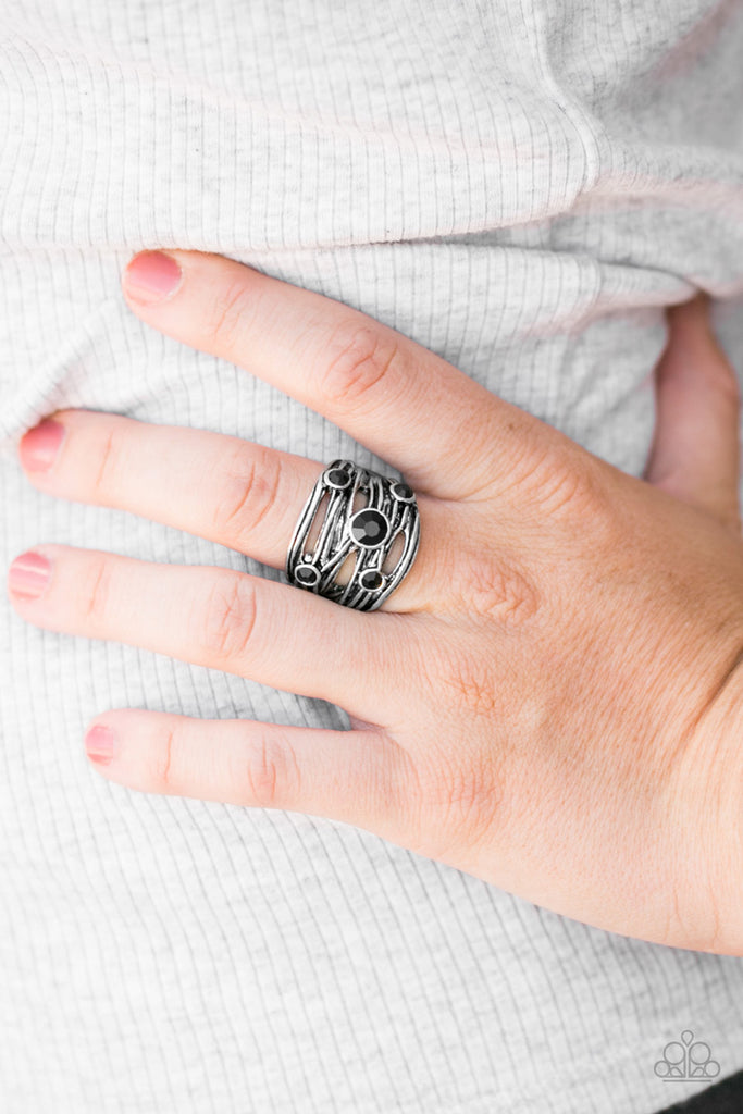 Brushed in an antiqued shimmer, shiny silver bands crisscross across the finger. Featuring faceted surfaces, glittery black rhinestones are sprinkled along the scattered silver bands for a haphazard finish.  Sold as one individual ring.  