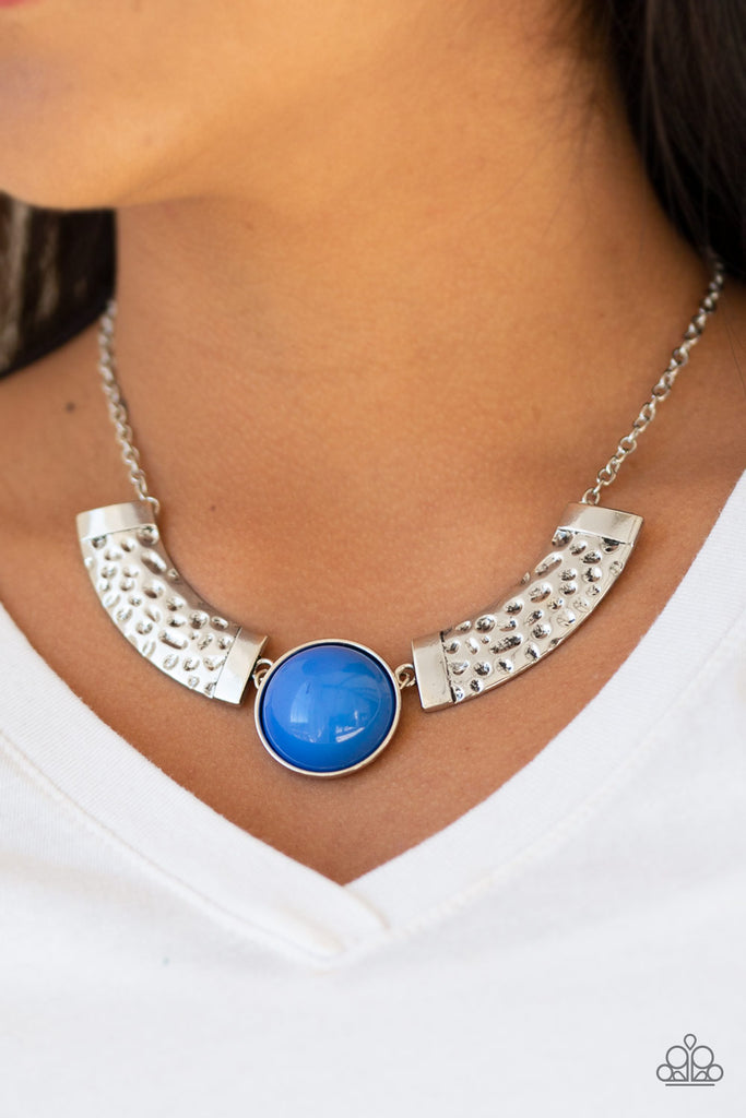 Dramatic silver plates connect with a shiny blue beaded center, creating an indigenous collar-like pendant. The shiny silver plates are delicately hammered, adding a flashy metallic texture to the tribal inspired palette. Features an adjustable clasp closure.  Sold as one individual necklace. Includes one pair of matching earrings.