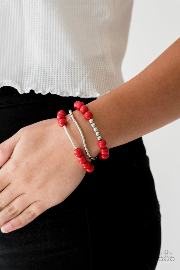Polished red beads and mismatched silver beads are threaded along stretchy bands, creating colorful layers across the wrist.  Sold as one set of three bracelets.
