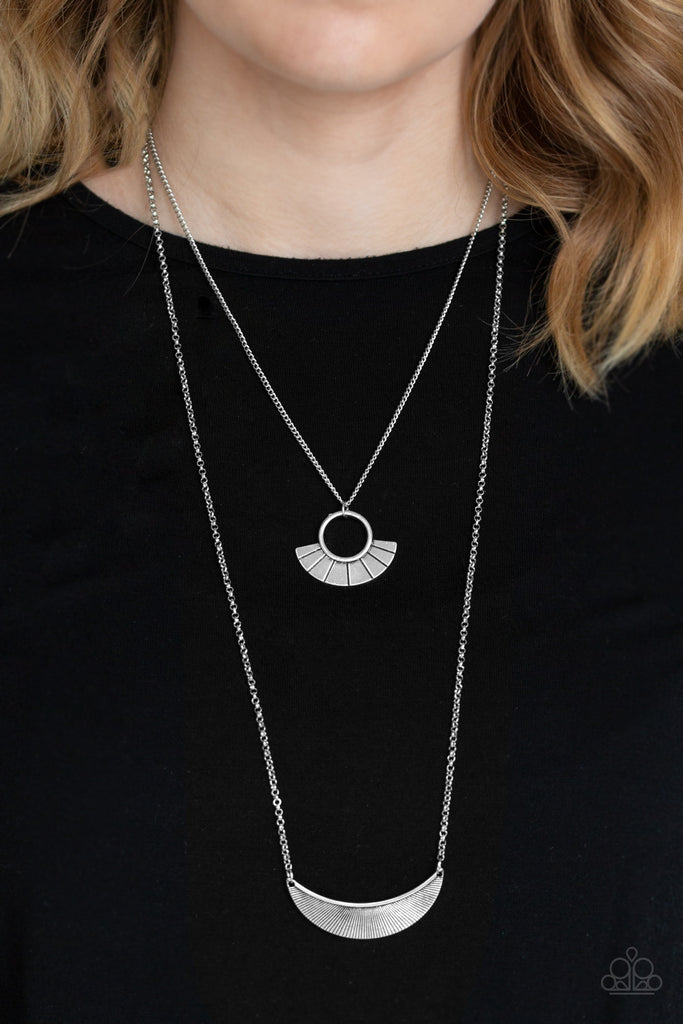 Radiating with linear patterns, a flared silver frame swings above a silver half-moon frame, creating tribal inspired layers below the collar. Features an adjustable clasp closure.  Sold as one individual necklace. Includes one pair of matching earrings.