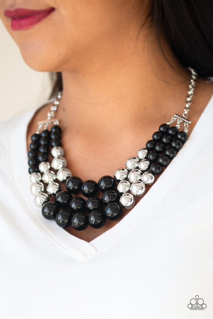 Gradually increasing in size near the center, a collection of black and silver beads layer below the collar in a statement-making fashion. Features an adjustable clasp closure.  Sold as one individual necklace. Includes one pair of matching earrings.