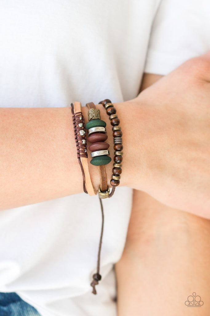 An array of wooden and metallic beads slide along mismatched strands of leather and shiny brown cording for an earthy look. Features an adjustable sliding knot closure.  Sold as one individual bracelet.