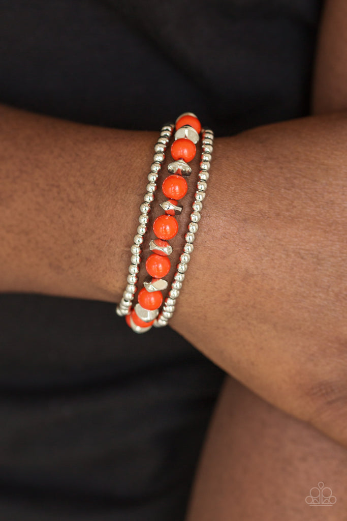 Polished orange beads and mismatched silver beads are threaded along stretchy bands for a seasonal look.  Sold as one set of three bracelets.