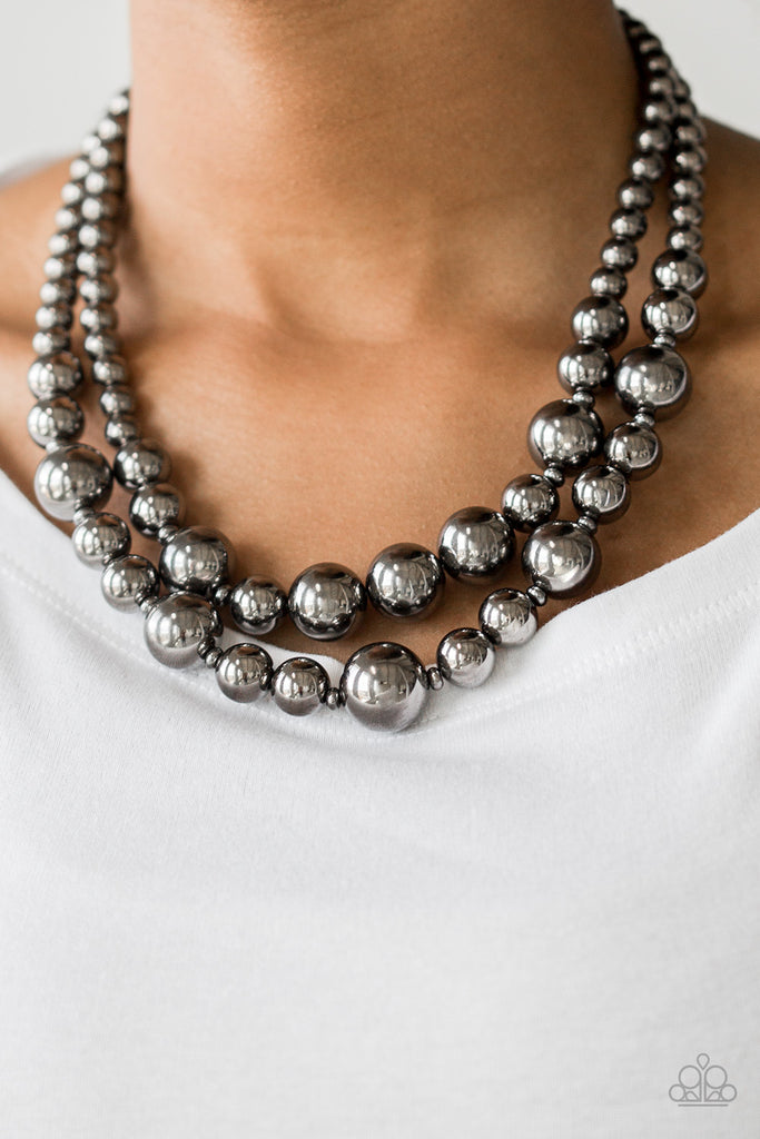 Gradually increasing in size near the center, strands of glistening gunmetal beads are threaded along invisible wires below the collar for a daring look. Features an adjustable clasp closure.  Sold as one individual necklace. Includes one pair of matching earrings.
