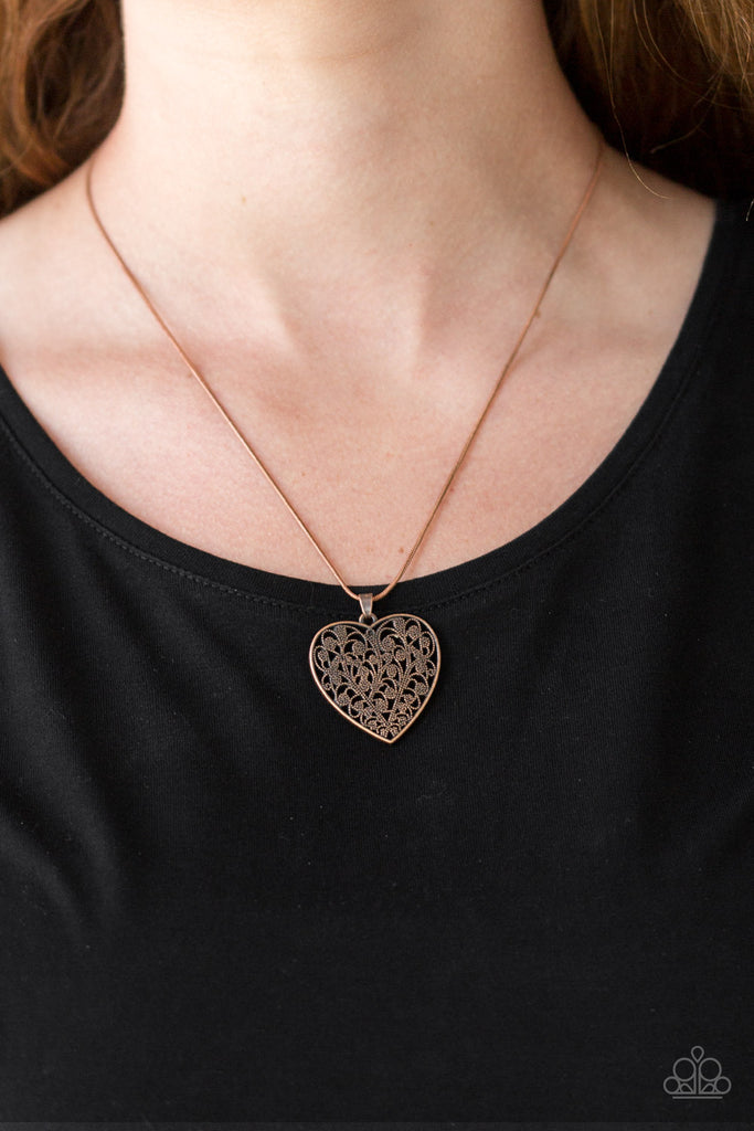 Filled with vine-like filigree detail, a copper heart pendant swings below the collar for a vintage inspired look. Features an adjustable clasp closure.  Sold as one individual necklace. Includes one pair of matching earrings.