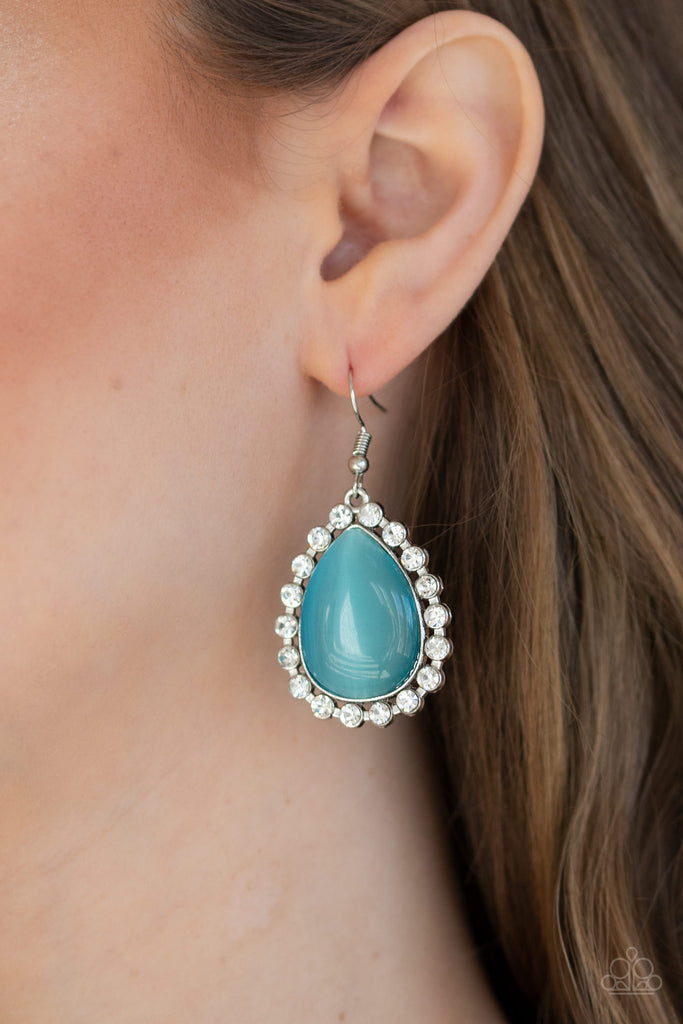 Glassy white rhinestones encircle a glowing blue cat's eye stone teardrop, creating an elegant frame. Earring attaches to a standard fishhook fitting.  Sold as one pair of earrings.