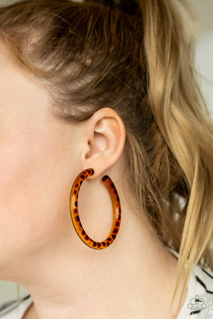Dotted in a brown finish, an acrylic hoop curls around the ear for a retro look. Earring attaches to a standard post fitting. Hoop measures 2 1/2" in diameter.  Sold as one pair of hoop earrings.